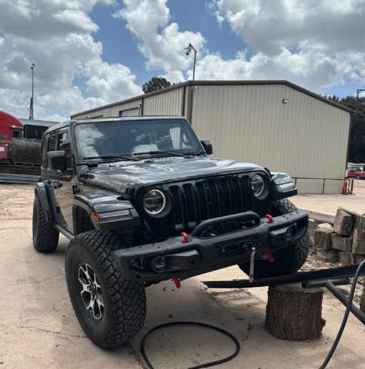 Installing suspension on a Jeep in a customer's driveway.