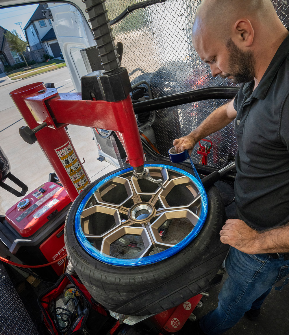 Garage2Go technician mounting a wheel in our mobile service van